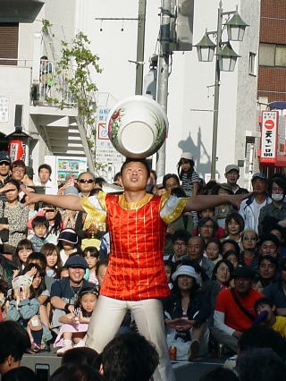 頭に１２キロの鉢を乗せる大道芸人