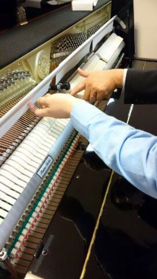 ピアノの説明をする営業マン